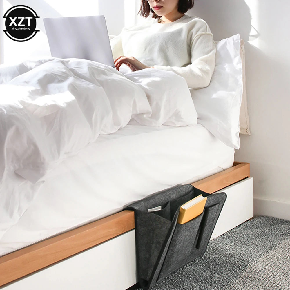 Felt bedside storage organizer, two-pocket grey hanging pouch for bed or sofa, holds notebook and book.