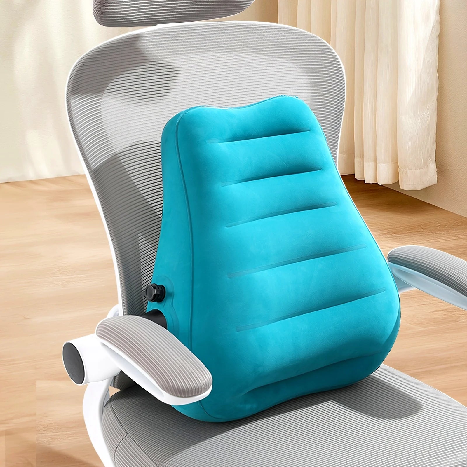 Ergonomic inflatable lumbar support pillow in teal attached to a gray-striped office chair back