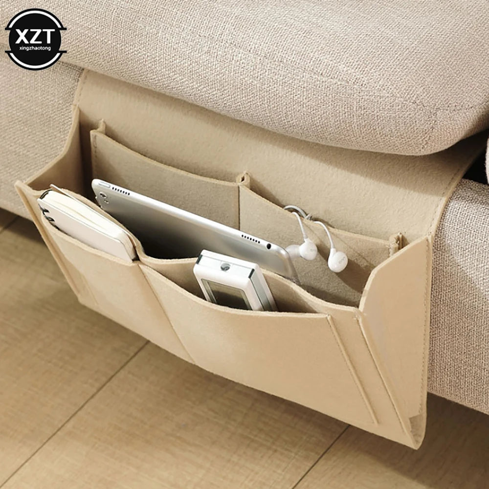 Felt bedside storage organizer with 3 pockets hanging from sofa, holding phone, tablet and earbuds; XZT logo visible.